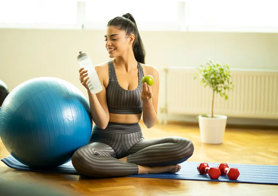 Woman exercising holding an apple