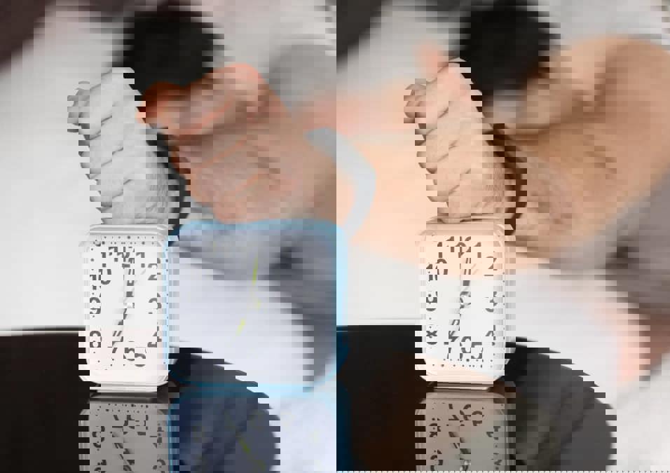 رجل يحاول تعديل برنامج نومه
