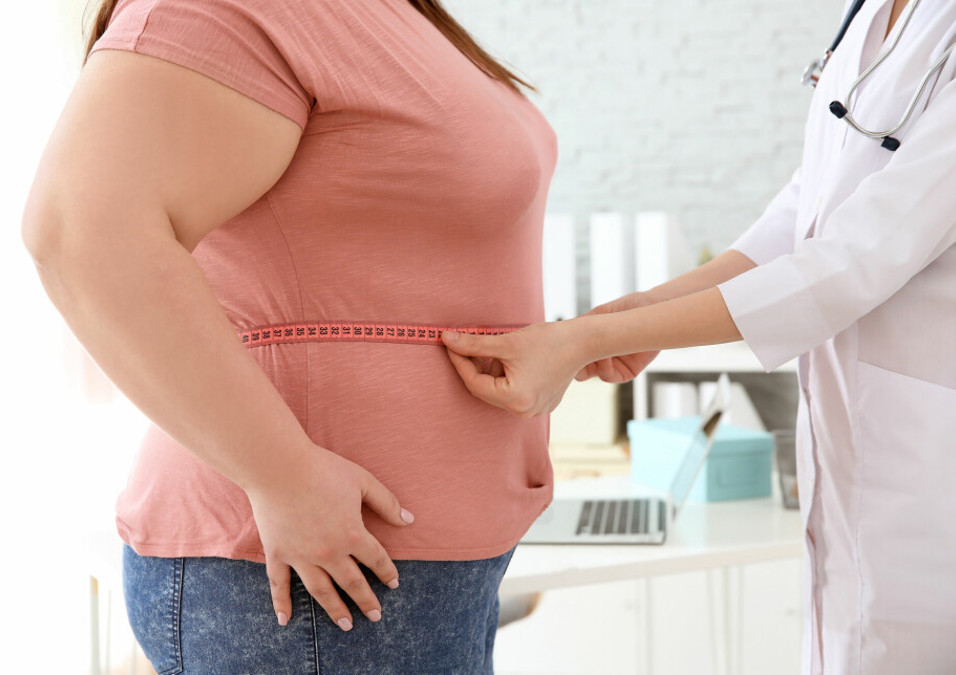A doctor measures a patient's waist