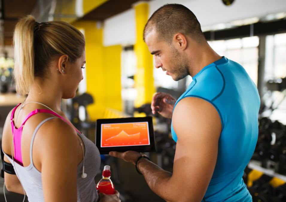 The trainer explains the technology on the tablet to the girl