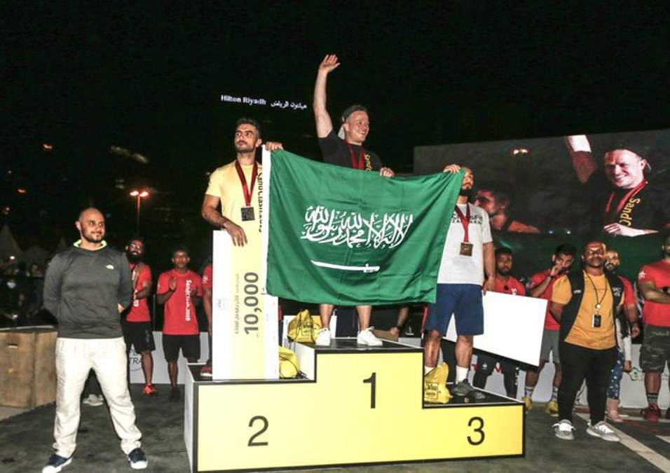 Three men carrying the Saudi flag