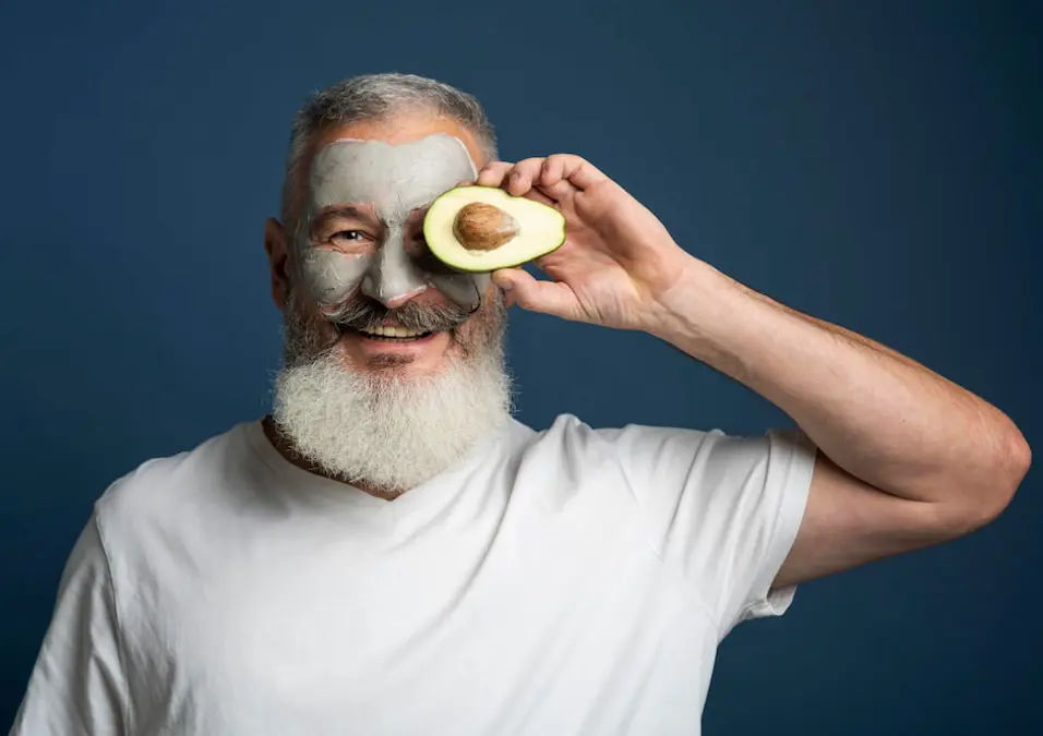 رجل يحمل أفوكادو مقطع، يوحي بفوائد الأفوكادو للرجال.