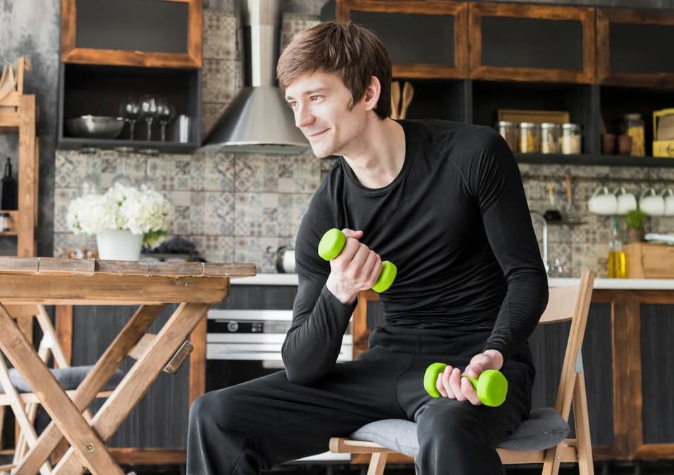 رجل يحمل الأثقال، يشير إلى نصائح وخطوات للمبتدئين لبناء العضلات.