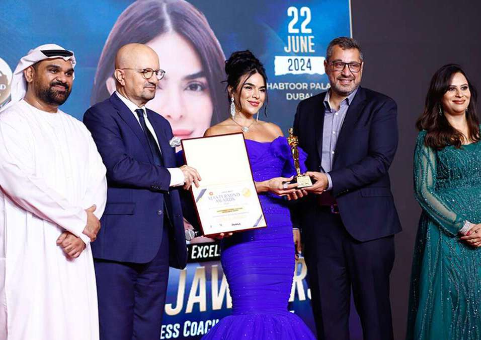 Three men and two women, two men handing an award to a woman