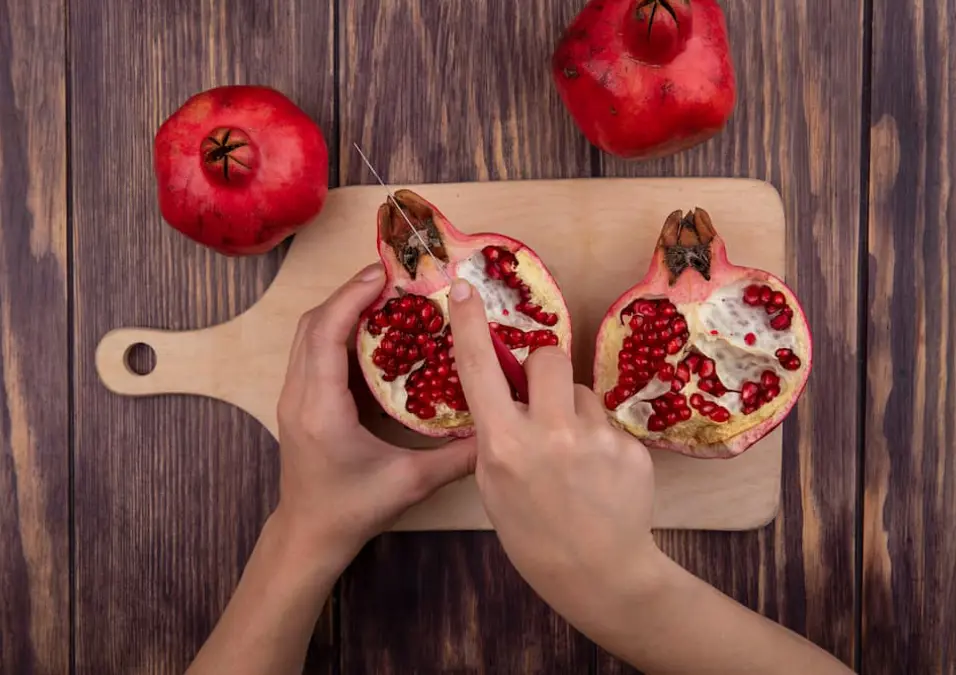 يدان تقطّعان رمانة على لوح خشبي، توحي بدوره في تعزيز الخصوبة والصحة الجنسية للرجال.