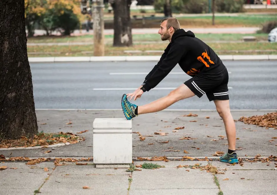 شاب يقوم بعمل تمارين استطالة للتخلص من التشنجات العضلية