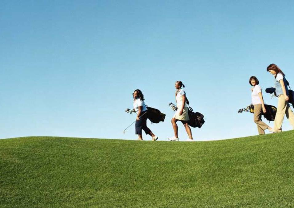 4 women walking on green grass