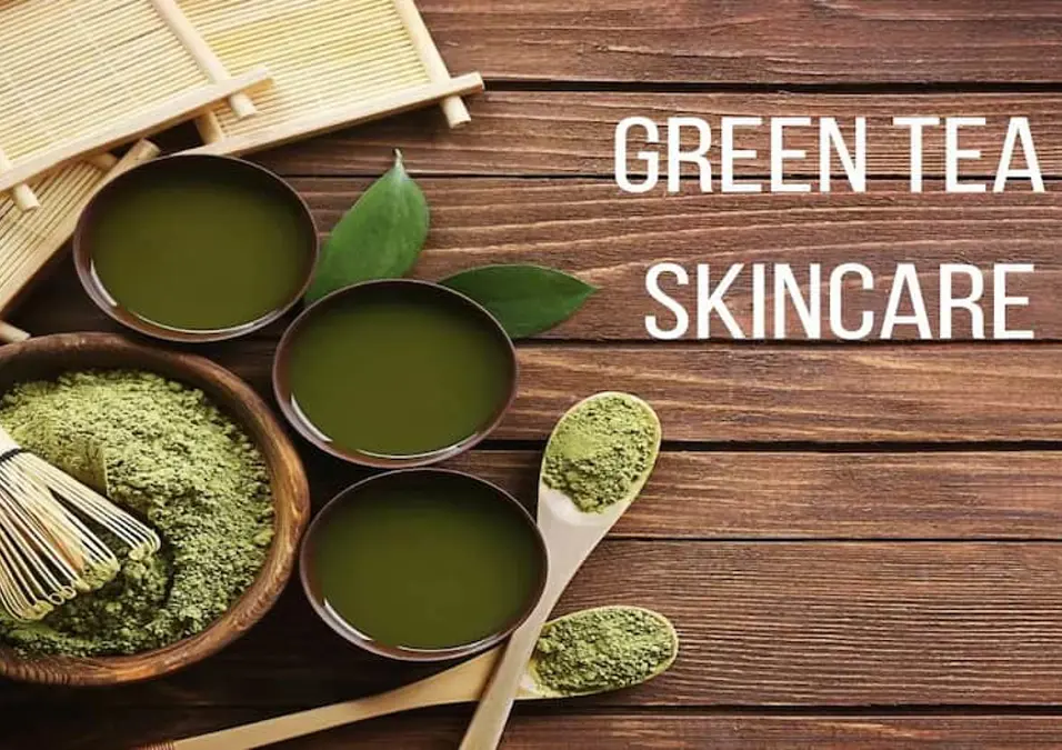 أوعية من الشاي الأخضر الجاهز ومسحوق الماتشا على طاولة خشبية، توحي بفوائد الشاي الأخضر للبشرة، لنضارة وحماية طبيعية.