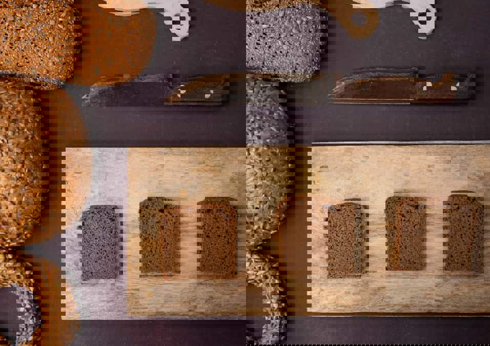 أنواع مختلفة من الخبز وثلاث شرائح على لوح تقطيع، مما يشير إلى بدائل فعالة للخبز