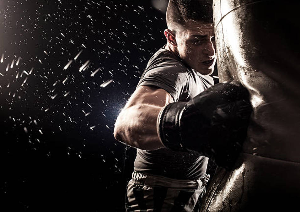 Man practicing boxing, throwing a punch with focus and intensity in Gymnation Boxing classes In Jeddah.