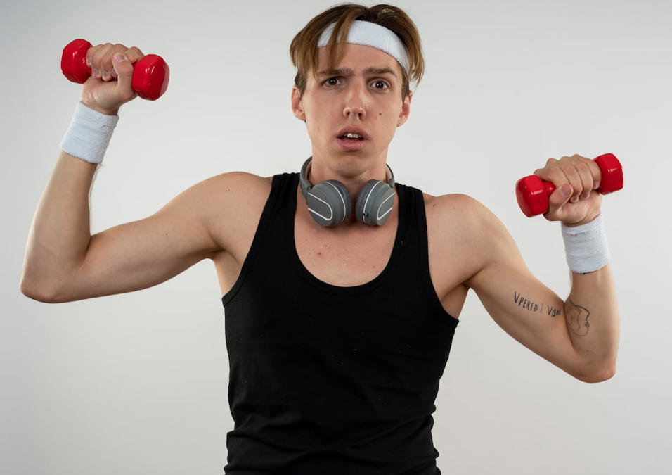 رجل متفاجئ يحمل الأثقال، مستعد لدليل بناء العضلات للنحاف والمبتدئين لزيادة الكتلة العضلية.