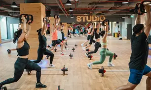 GNGroup of people doing Les Mills BODYPUMP class at GymNation Dubai, using barbells and SMARTBAR equipment
